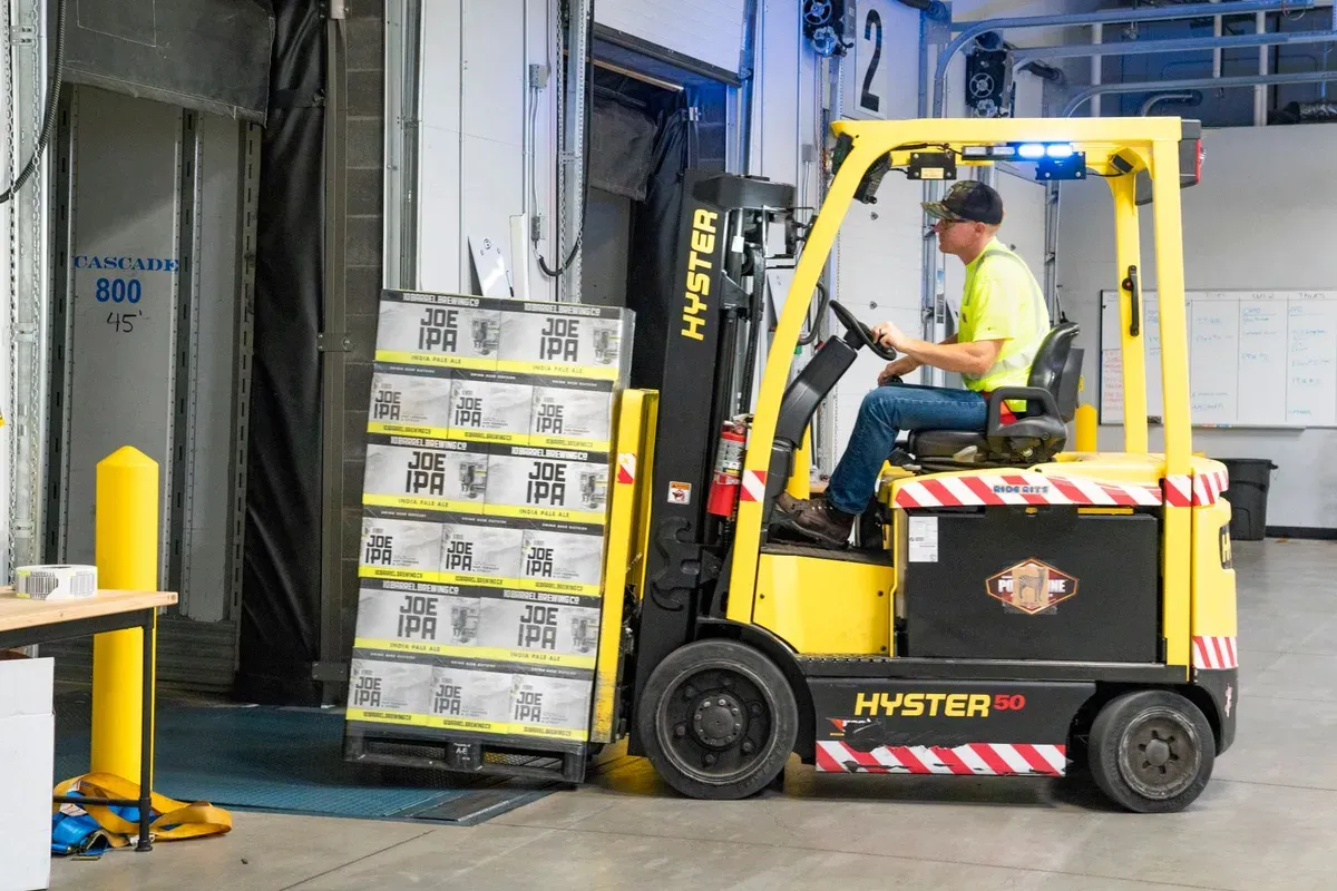 Operai che caricano cartoni di mobili smontati in un container 40ft high cube in un magazzino di consolidamento