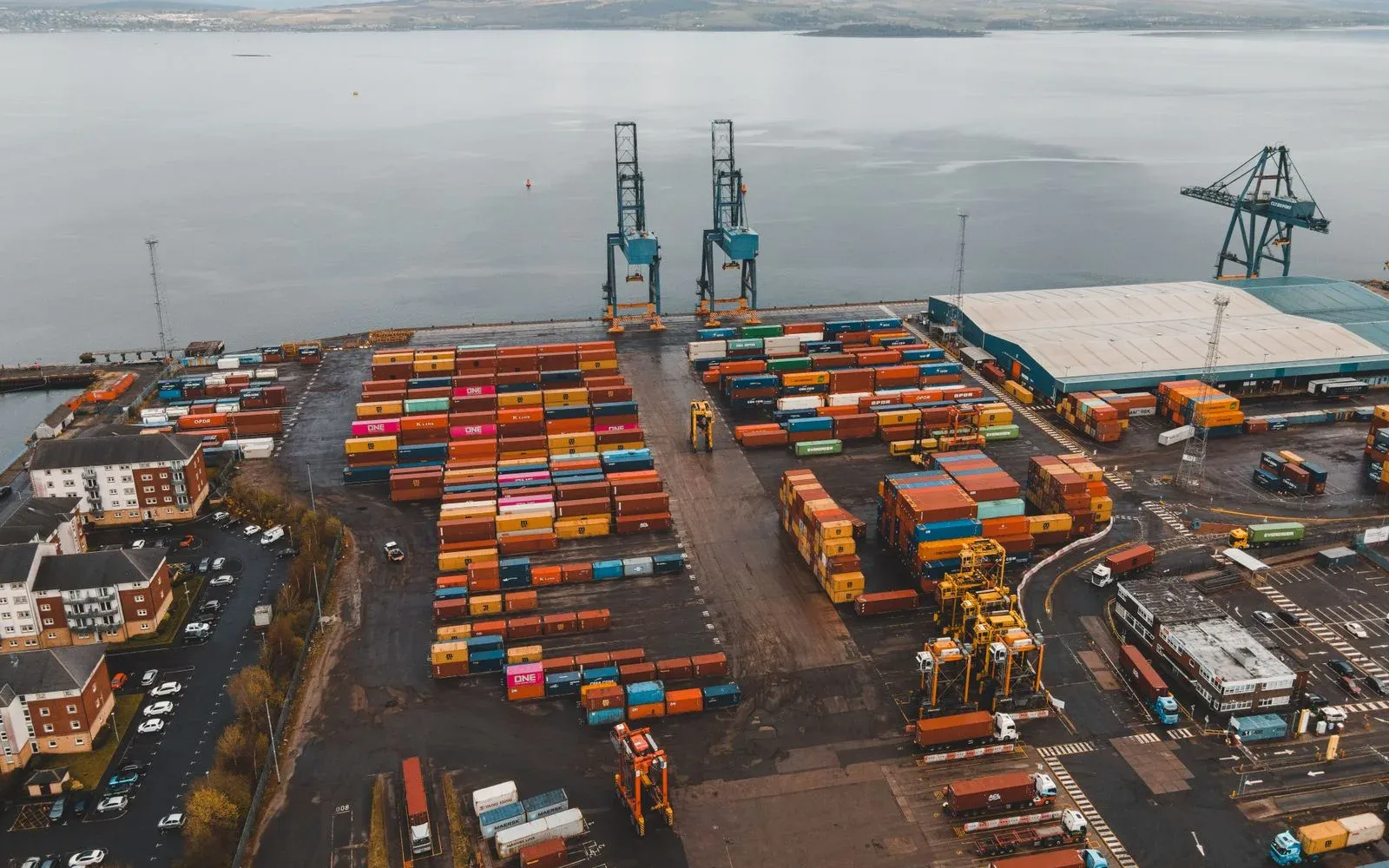 Aerial view of a container terminal with stacked containers and gantry cranes